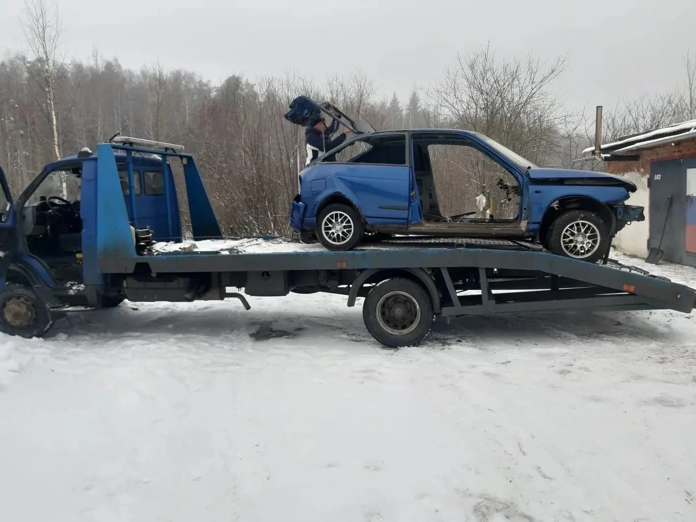 Сильно повреждённый автомобиль после ДТП на эвакуаторе