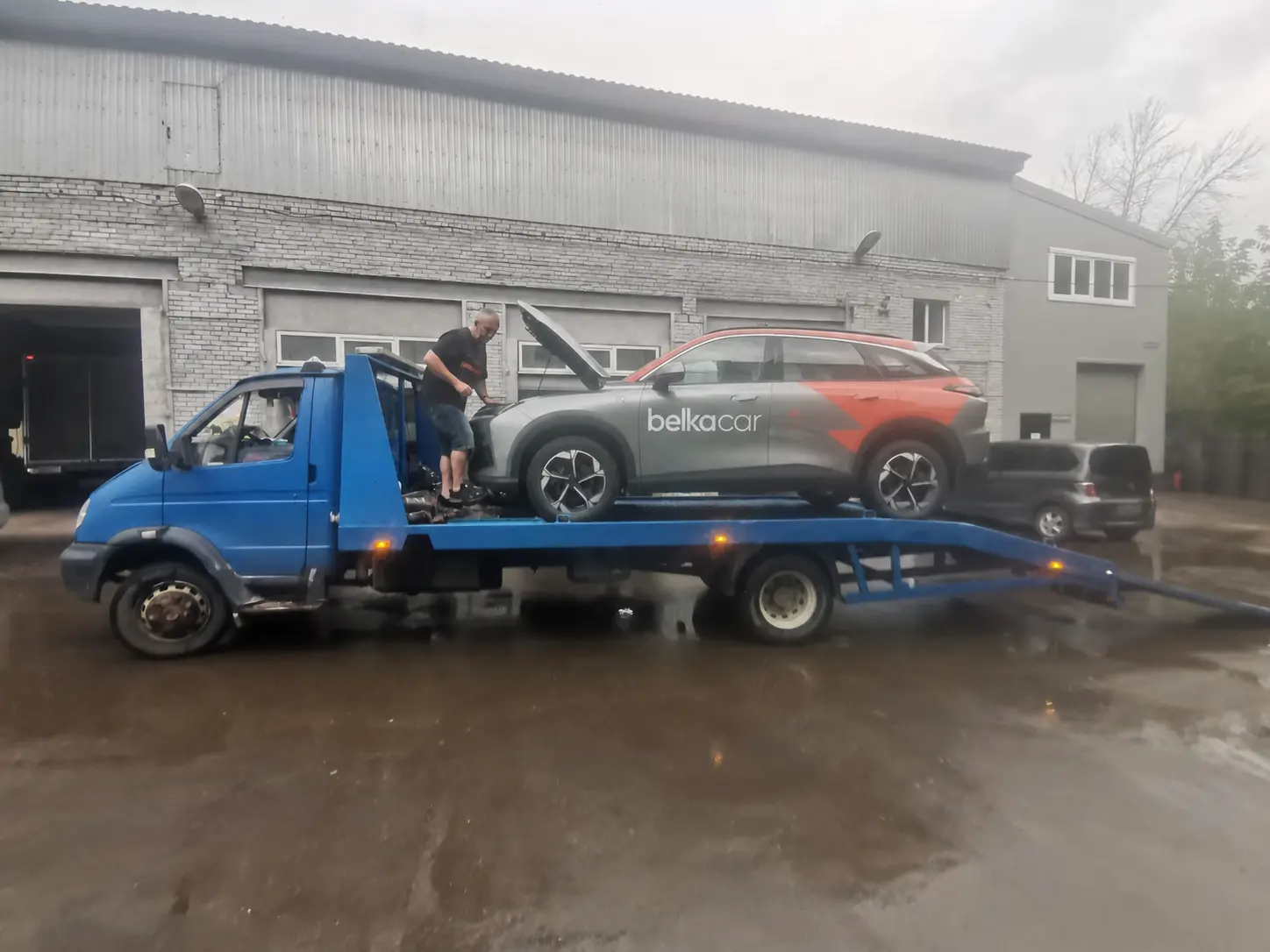 Кроссовер BelkaCar на синем эвакуаторе у автосервиса