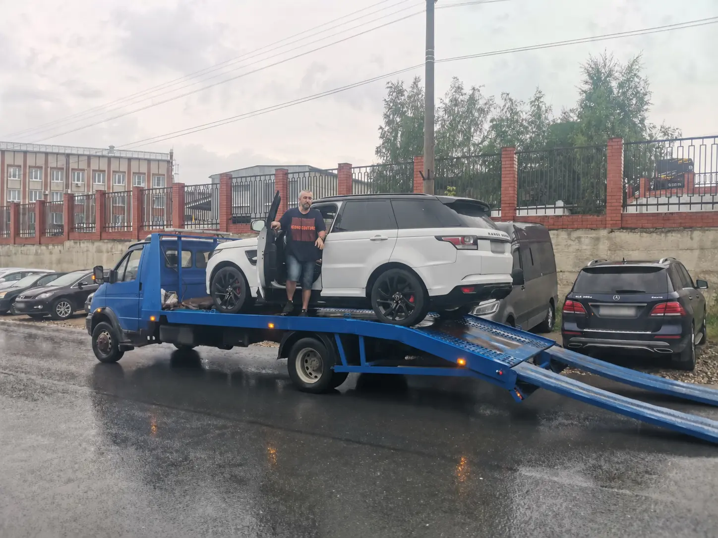 Белый Range Rover на синем эвакуаторе